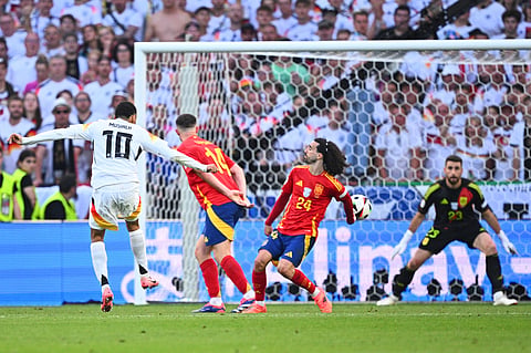 Germany's Jamal Musiala, left, shoots sthe ball against Spain's Marc Cucurella, center, during a quarterfinal match between Germany and Spain at the Euro 2024 soccer tournament in Stuttgart, Germany, Friday, July 5, 2024. 
